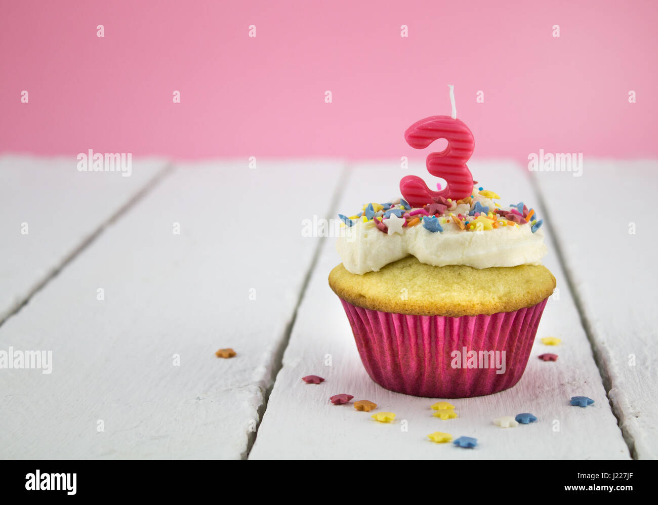 Buon compleanno Cup cake con star spruzza e numero 3 candela rosa sul tavolo bianco con sfondo rosa - Festa di compleanno sfondo per ragazza Foto Stock