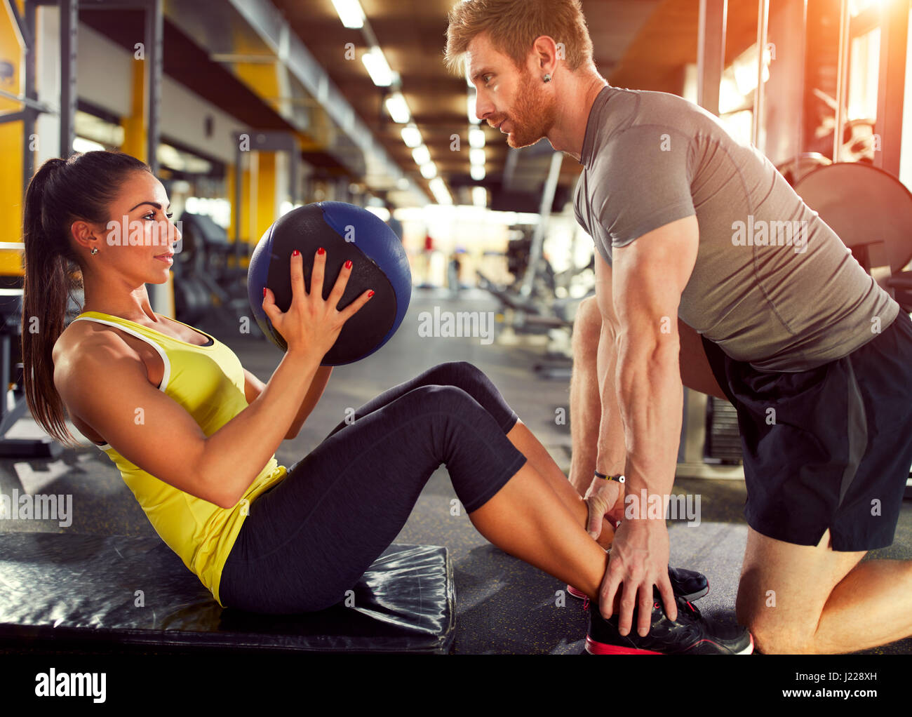 Esercizio femmina six pack i muscoli con il partner in palestra Foto Stock