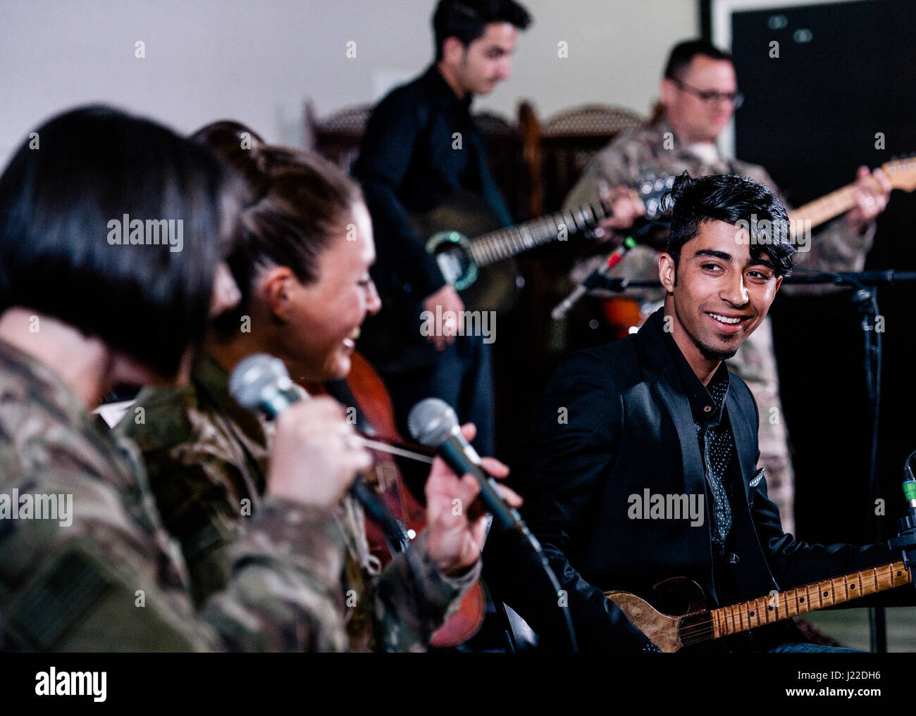 Stati Uniti Air Force del comando centrale dei sistemi di banda andare cantanti, cantare insieme con Ahmadullah Nabizada afghana Istituto Nazionale di Musica studente, durante una performance presso l'U.S. Ambasciata a Kabul, Afghanistan, Marzo 26, 2017. Sistemi e gli studenti di anim erano canzoni di preformatura che includeva tradizionali e moderne canzoni dall' Afghanistan per una vasta folla di gente del posto e il personale. (U.S. Air Force foto di Senior Airman Giordania Castelan) Foto Stock