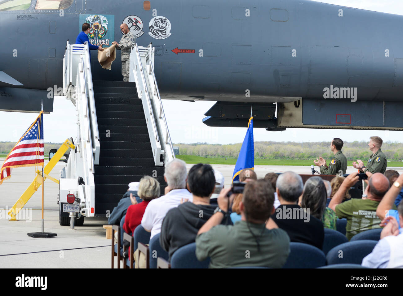 Becky Thatcher, figlia del compianto Doolittle Raider Staff Sgt. David Thatcher, E DEGLI STATI UNITI Air Force Tech. Sgt. William Hatten, 28 squadrone di manutenzione da Ellsworth Air Force Base, S.D., rotto Duck dedicato capo equipaggio, svelano la più recente riedizione di rotte illustrazioni di anatra di fronte ad una folla durante una cerimonia, apr. 17, 2017 a Wright-Patterson Air Force Base in Ohio. L'opera d'arte originale presentava un cross-eyed duck indossa un casco di cuoio, fissando su attraversato stampelle. (U.S. Air Force foto di Wesley Farnsworth) Foto Stock