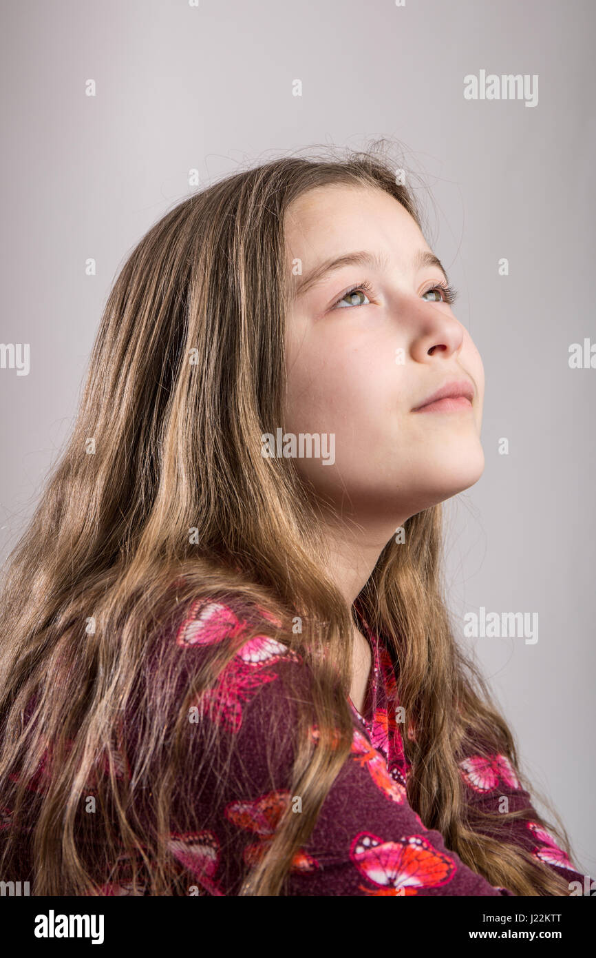 Ritratto di un undici anno vecchia ragazza guarda pensieroso Foto Stock