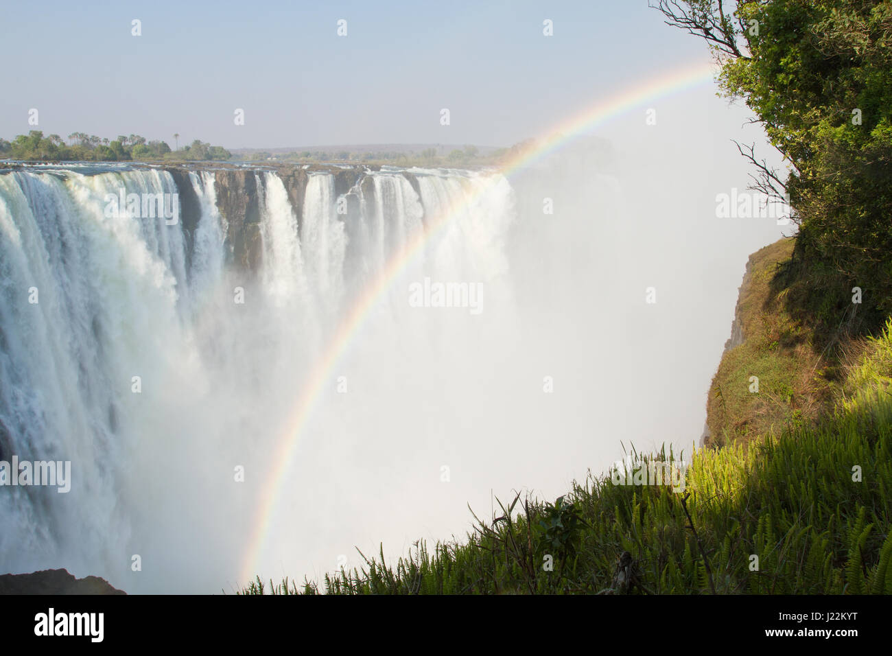 La cataratta Vista Isola di Victoria Falls con rainbow in Zimbabwe, Africa Foto Stock