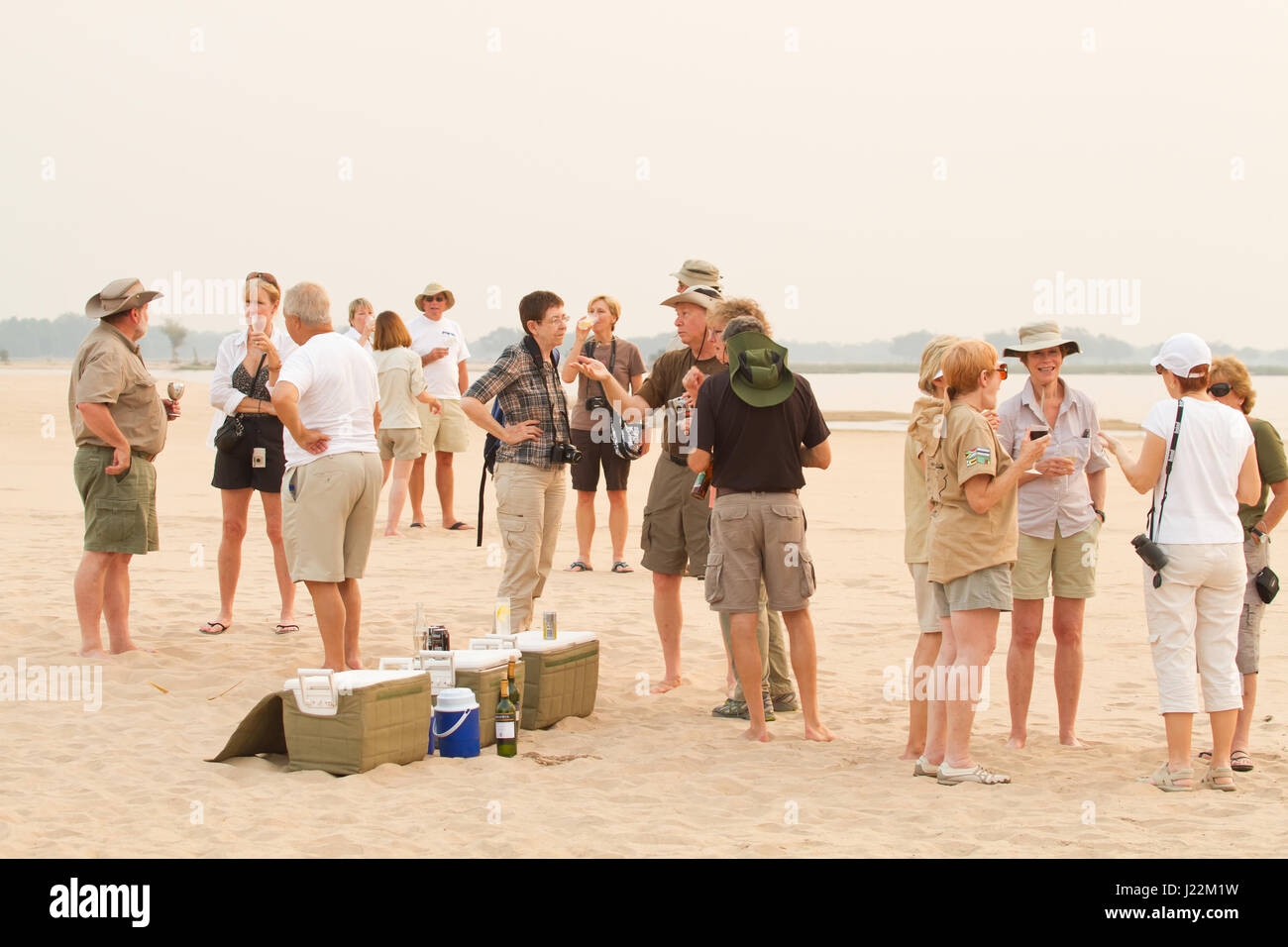 Per coloro che godono di un safari sundowner party sulla spiaggia accanto al fiume Zambezi in Lower Zambezi National Park, Zambia, Africa Foto Stock