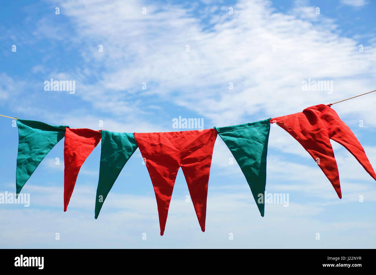 Blu e rosso fiamme appeso sopra il cielo blu Foto Stock