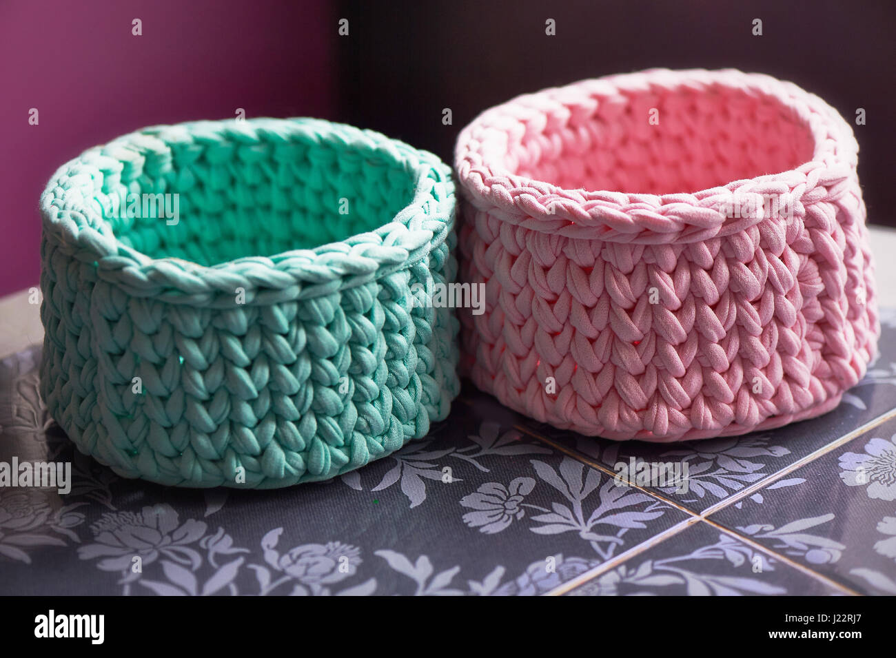 Cestelli - turchese e crochet rosa intorno al cerchio di maglieria, realizzata in tessuto.Close Foto Stock