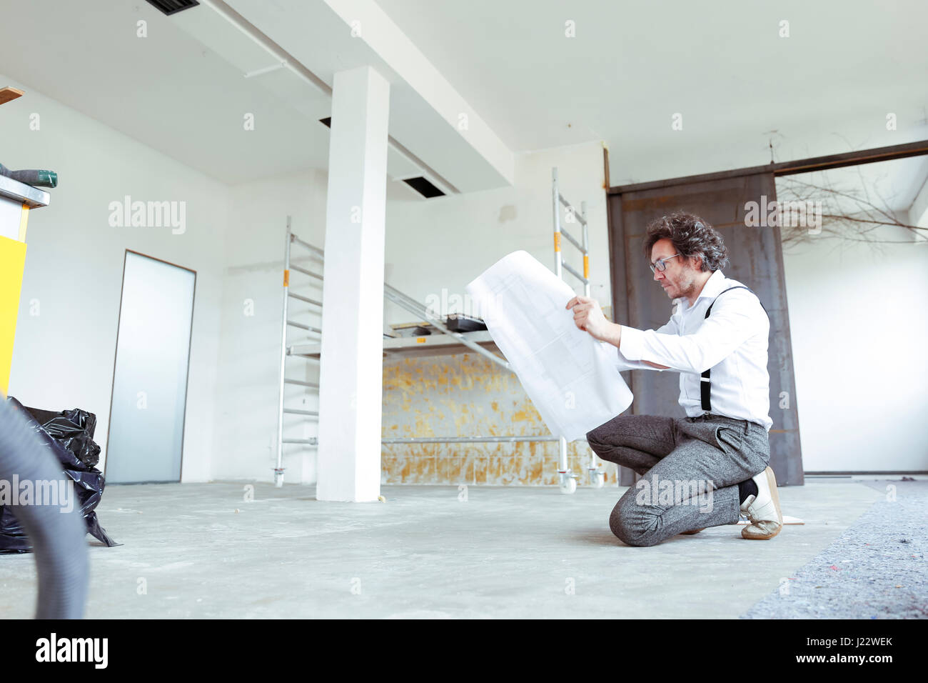 Architetto con piano di costruzione al sito in costruzione Foto Stock