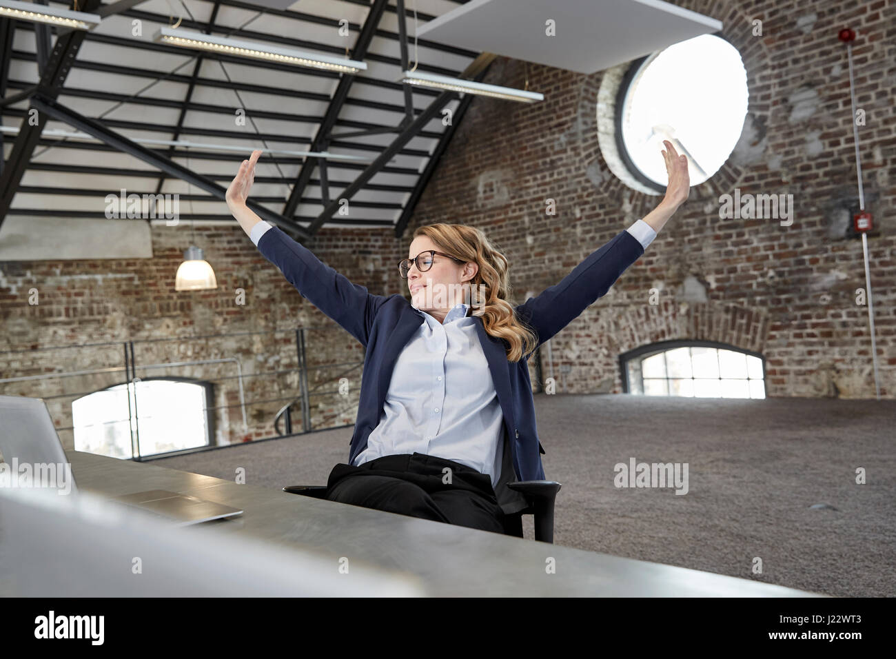 Imprenditrice stiro a tavola in un loft Foto Stock