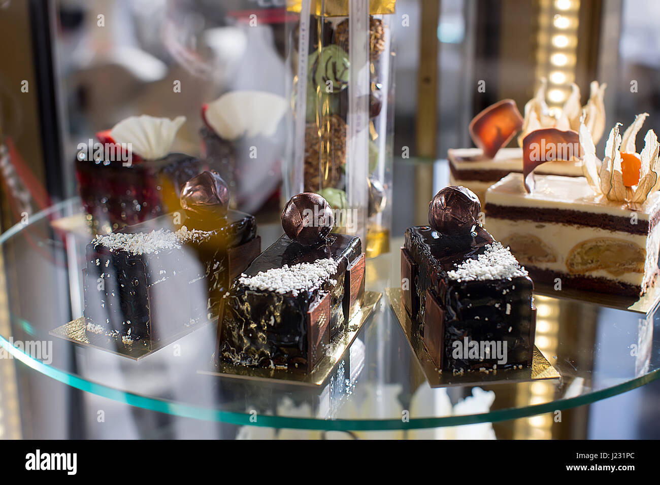 Dessert vari sulla vetrina di vetro Foto Stock