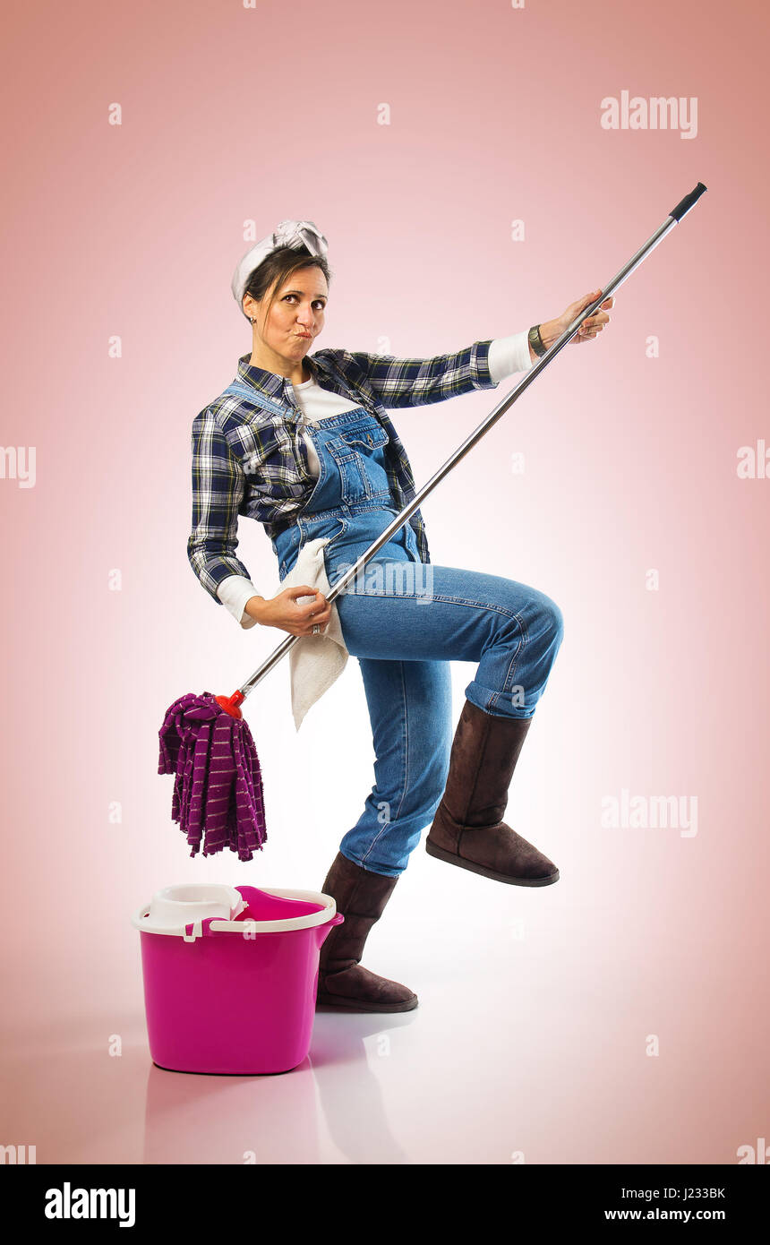 Donna sorridente con straccio e secchio pronto per pulire il pavimento su  sfondo rosa Foto stock - Alamy