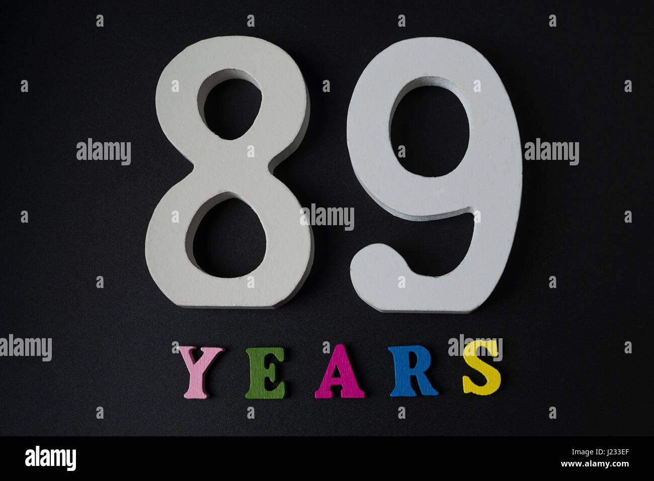 Lettere e numeri ottanta-nove anni su un isolato nero lo sfondo. Foto Stock