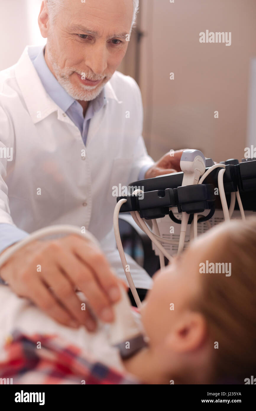 Sorridente medico utilizzando ultrasuoni trasduttore lineare in ospedale Foto Stock