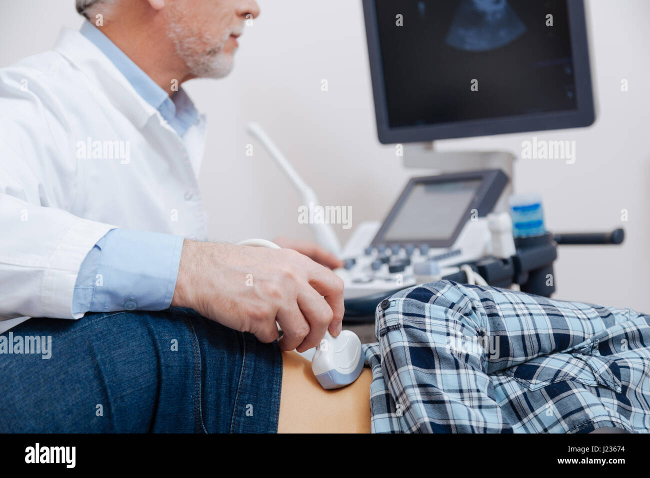 Anziani curante utilizzando apparecchiature a ultrasuoni in clinica Foto Stock