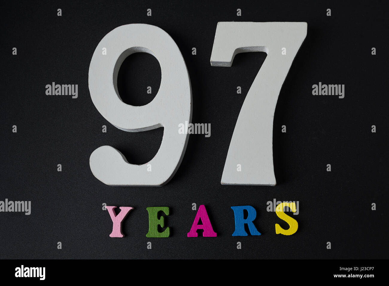 Lettere e numeri novanta sette anni su un isolato nero lo sfondo. Foto Stock