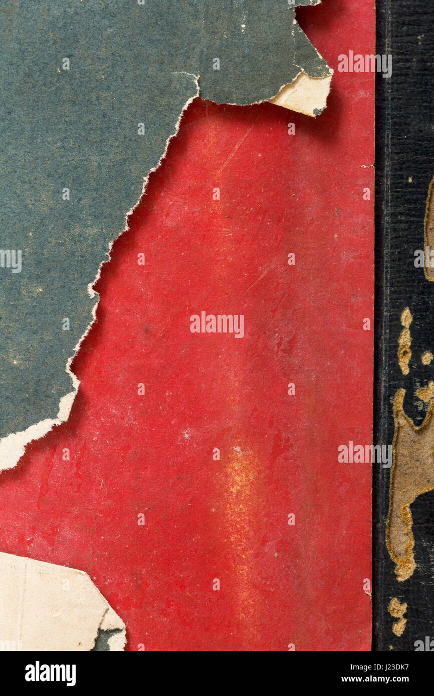 Dettaglio di un libro di età compresa tra il coperchio con ingiallito tagliente come vintage sfondo carta sbiadito in rosso, verde e nero i colori Foto Stock