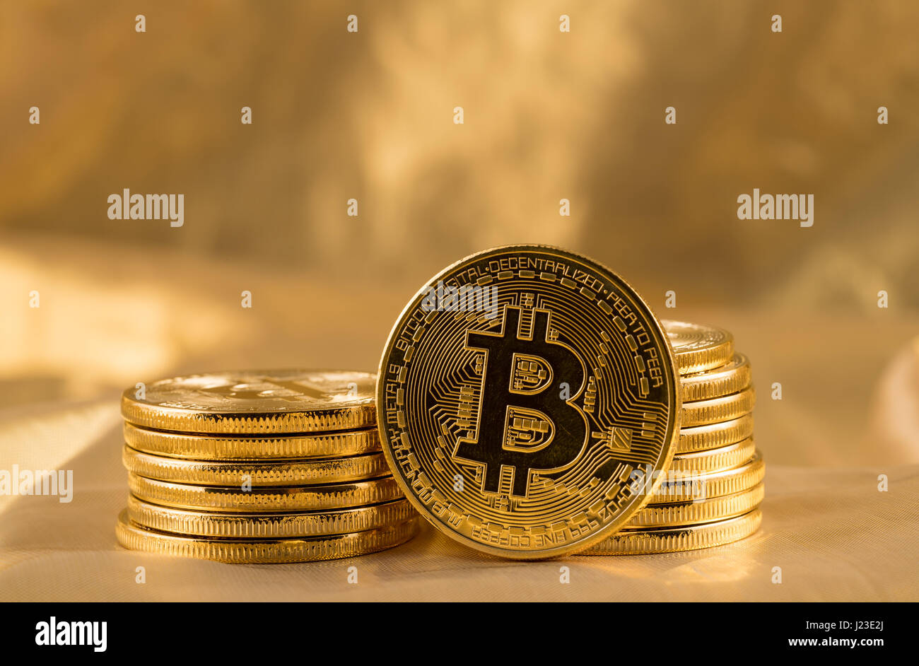 Pila di monete di bit o bitcoin su fondo oro per illustrare blockchain e cyber valuta Foto Stock