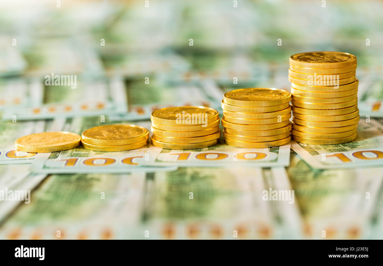 Pila di oro americano eagle Gold bullion monete palo in aumento la crescita su nuovo design della valuta statunitense Hundred Dollar Bills Foto Stock