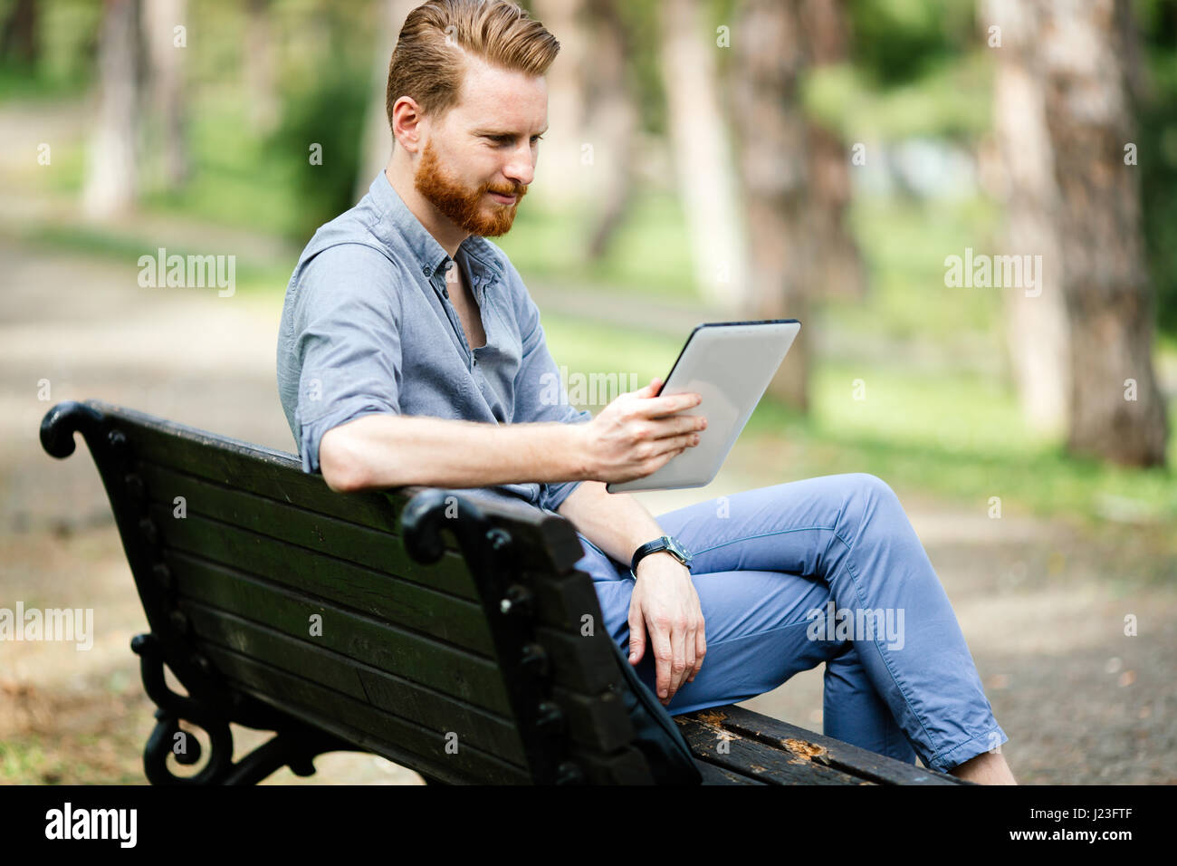 Imprenditore utilizzando tablet pc in posizione di parcheggio e rilassante Foto Stock