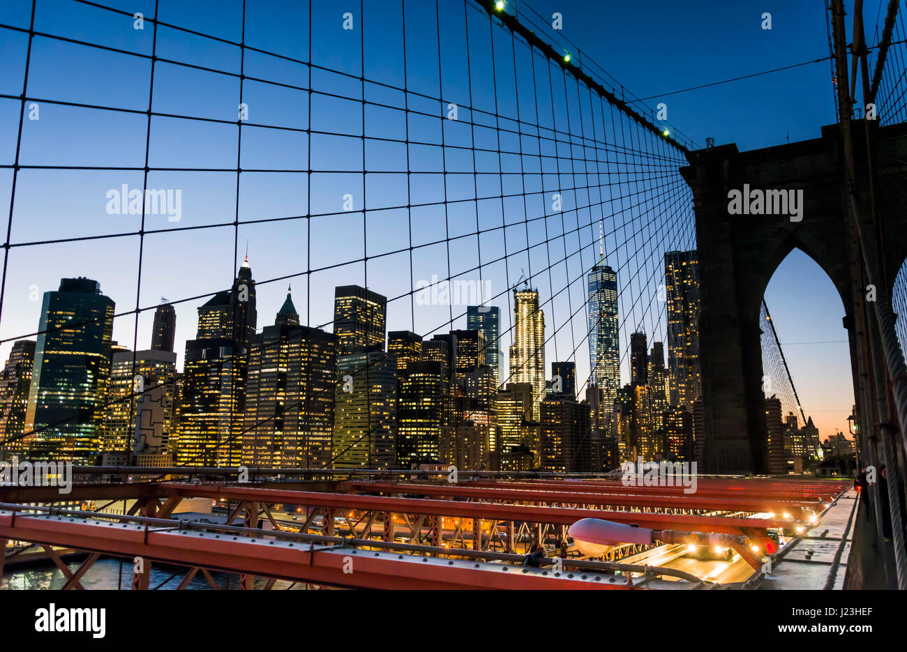 Skyline di New York dal ponte di Brooklyn al tramonto Foto Stock