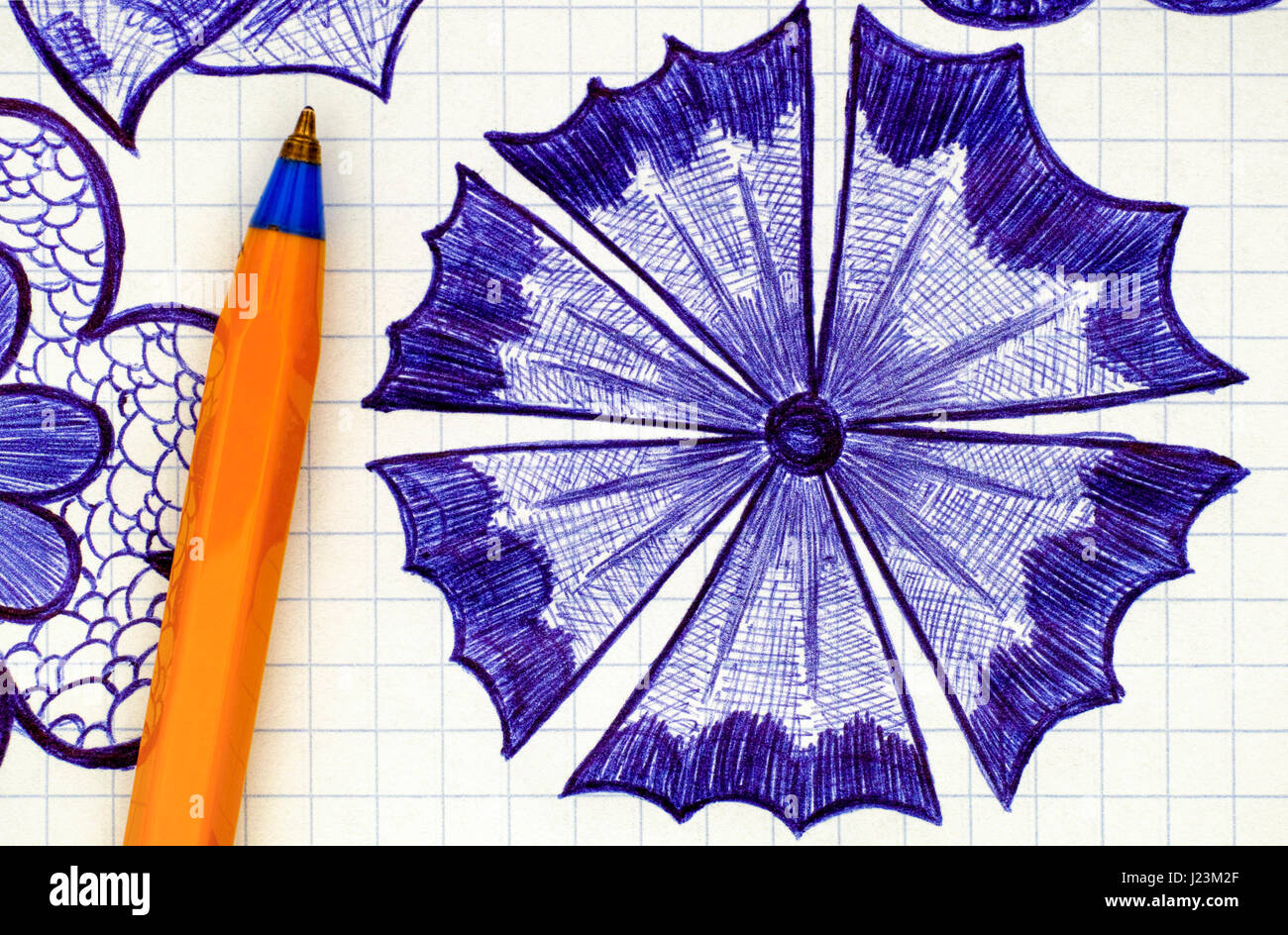 Close-up di disegnati a mano fiore sul foglio di carta a scacchi con orange penna a sfera. Doodle stile. Foto Stock