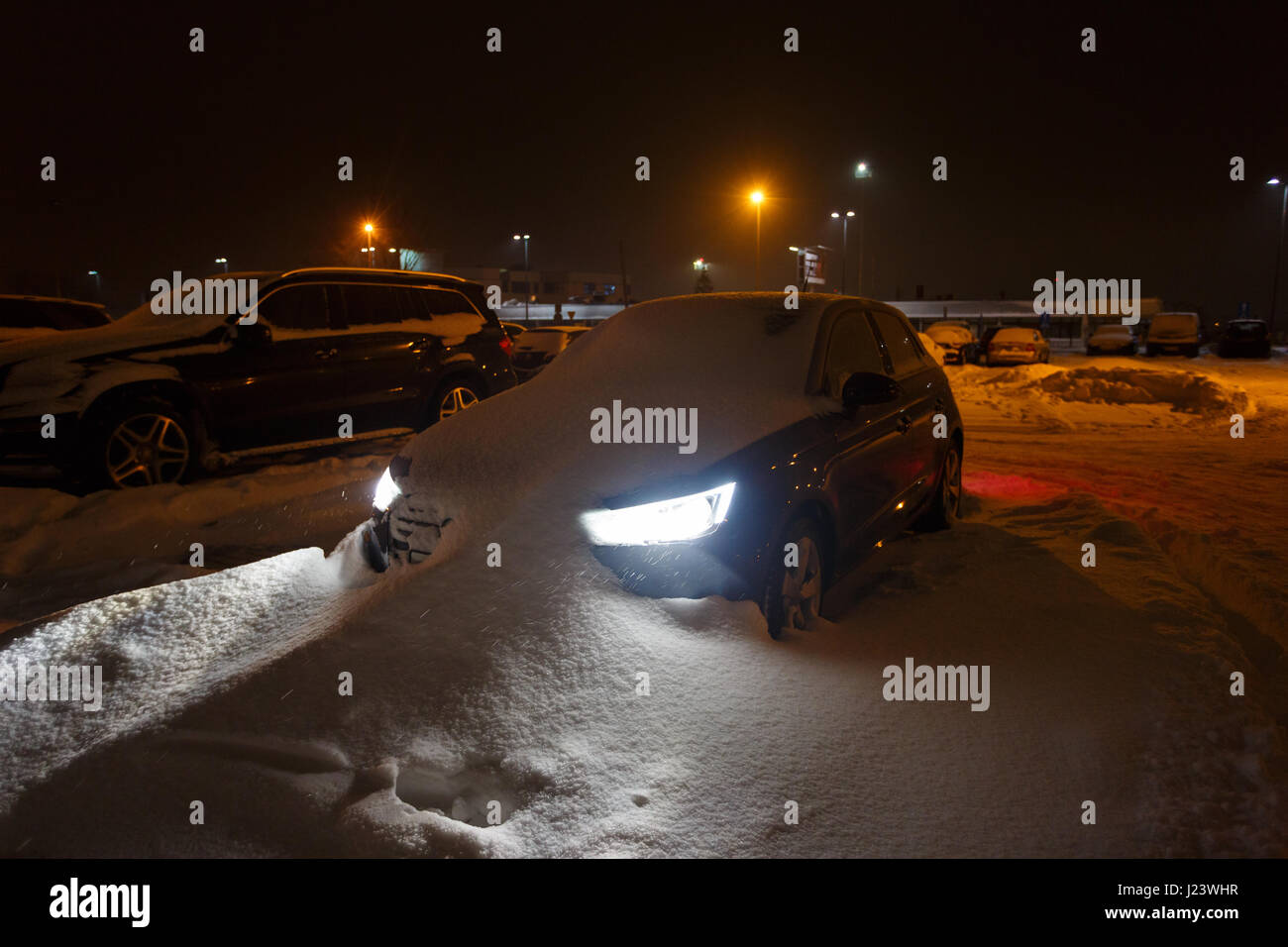 Macchina bloccata nel cumulo di neve di notte Foto Stock