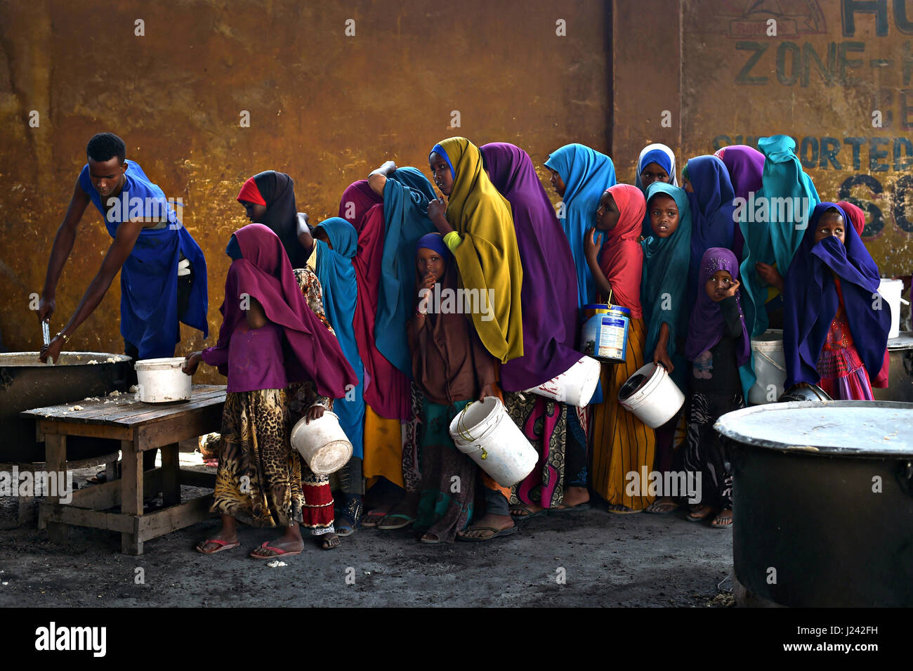 Giovani ragazze Somalia line up per il porridge in corrispondenza di un centro di alimentazione 9 marzo 2017 a Mogadiscio, in Somalia. La Somalia sta vivendo un periodo di grave siccità e può essere sull orlo della carestia a meno urgente azione umanitaria è presa al più presto. Foto Stock