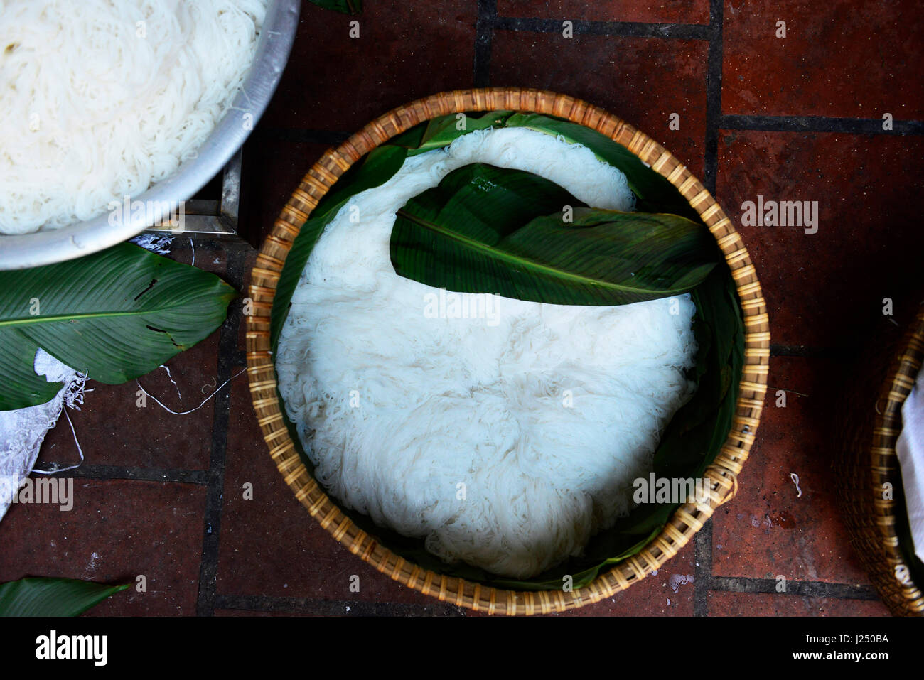 Preparazione della tradizionale vietnamita spaghetti di riso ( Bún ) in una piccola famiglia di proprietà di fabbrica in un piccolo villaggio nei pressi di Hanoi. Foto Stock