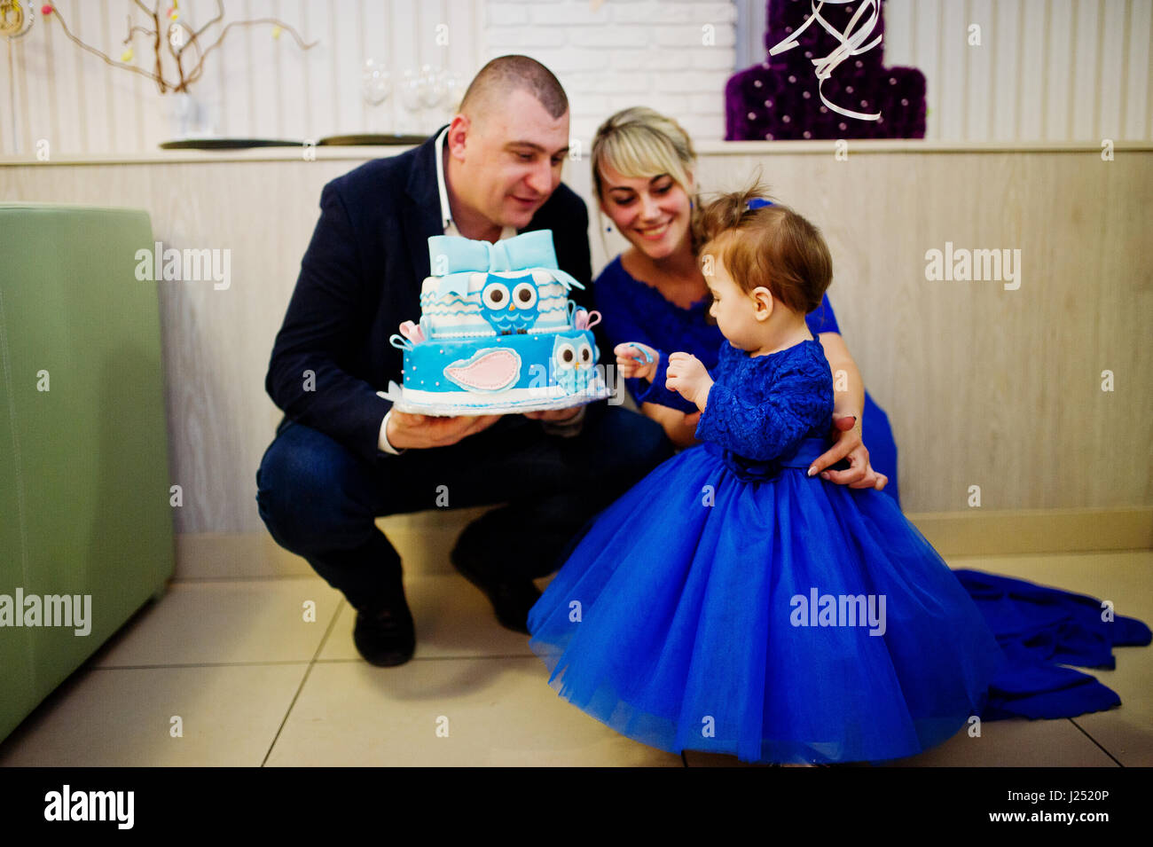 Incantevole piccola bambina al vestito blu con 1 anno di torta di  compleanno e il padre e la madre Foto stock - Alamy