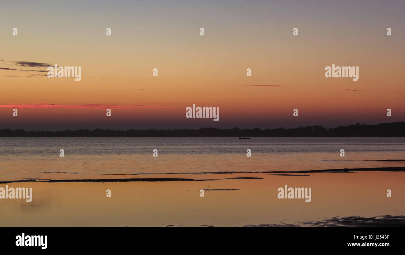 Bellissimo tramonto sul lago calmo, barca silhouette Foto Stock