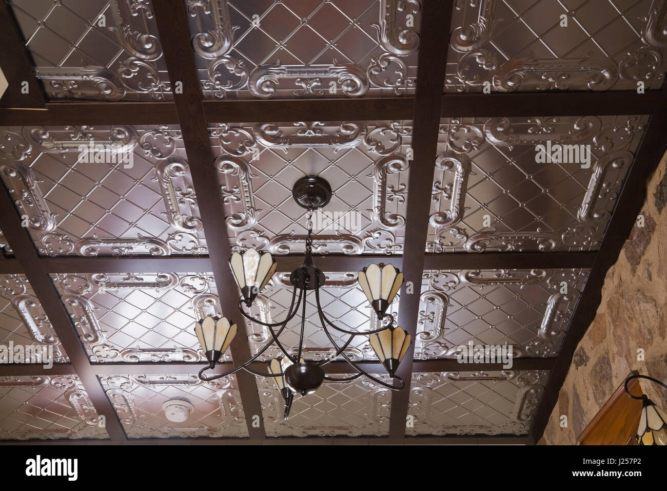 Stampigliato tin soffitto a cassettoni all'interno di un vecchio Canadiana cottage in stile fieldstone casa residenziale. Foto Stock