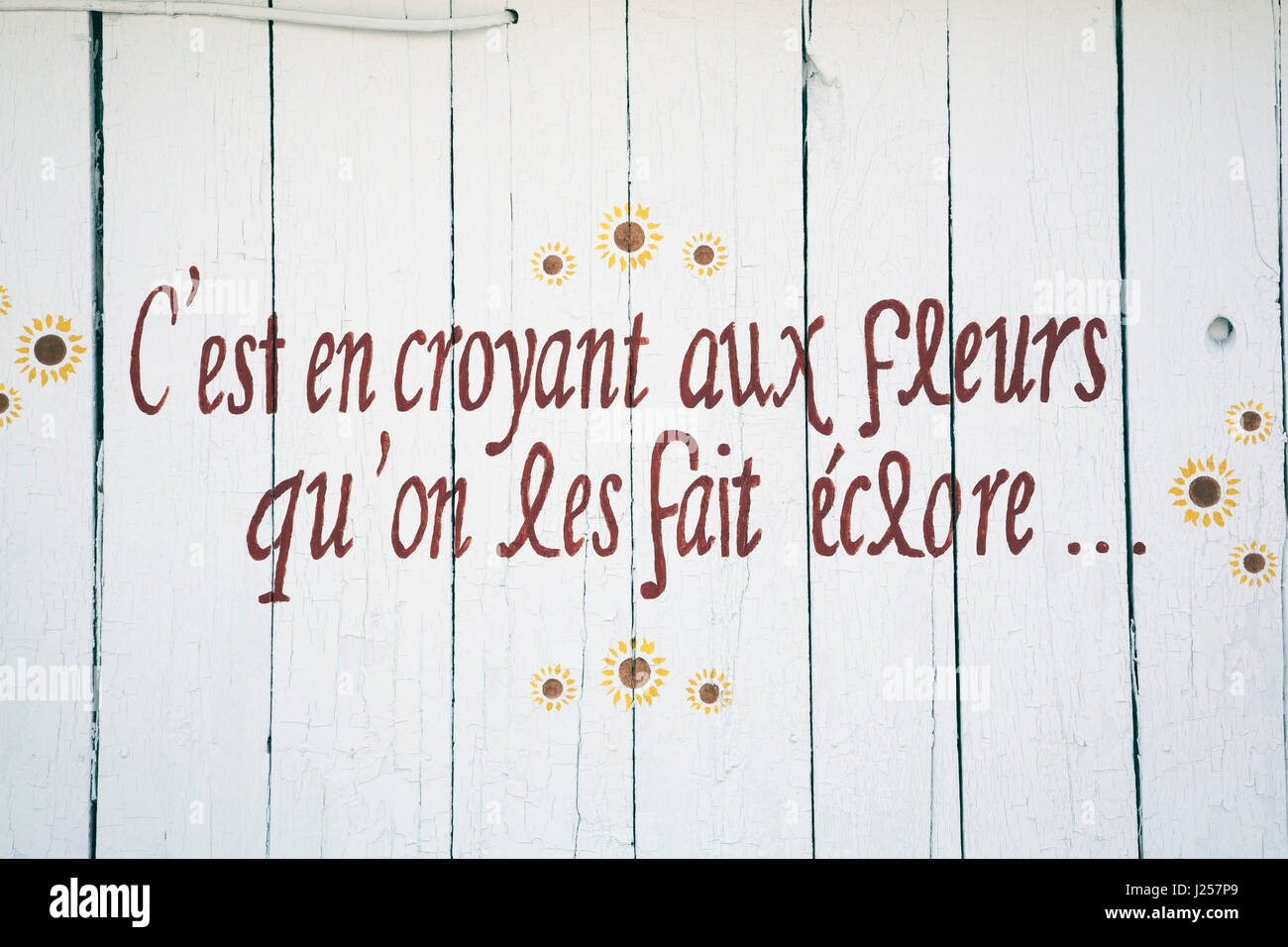 Frase poetica in lingua francese dipinta sul lato di a. Fienile che legge 'il suo credendo in fiori che noi rendili fiorire' Foto Stock