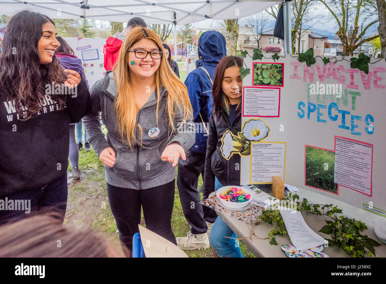 Windermere gli studenti della scuola secondaria con specie invasive consapevolezza tabella alla Giornata della Terra parata e Festival, organizzato da "Gioventù per la giustizia climatica N Foto Stock