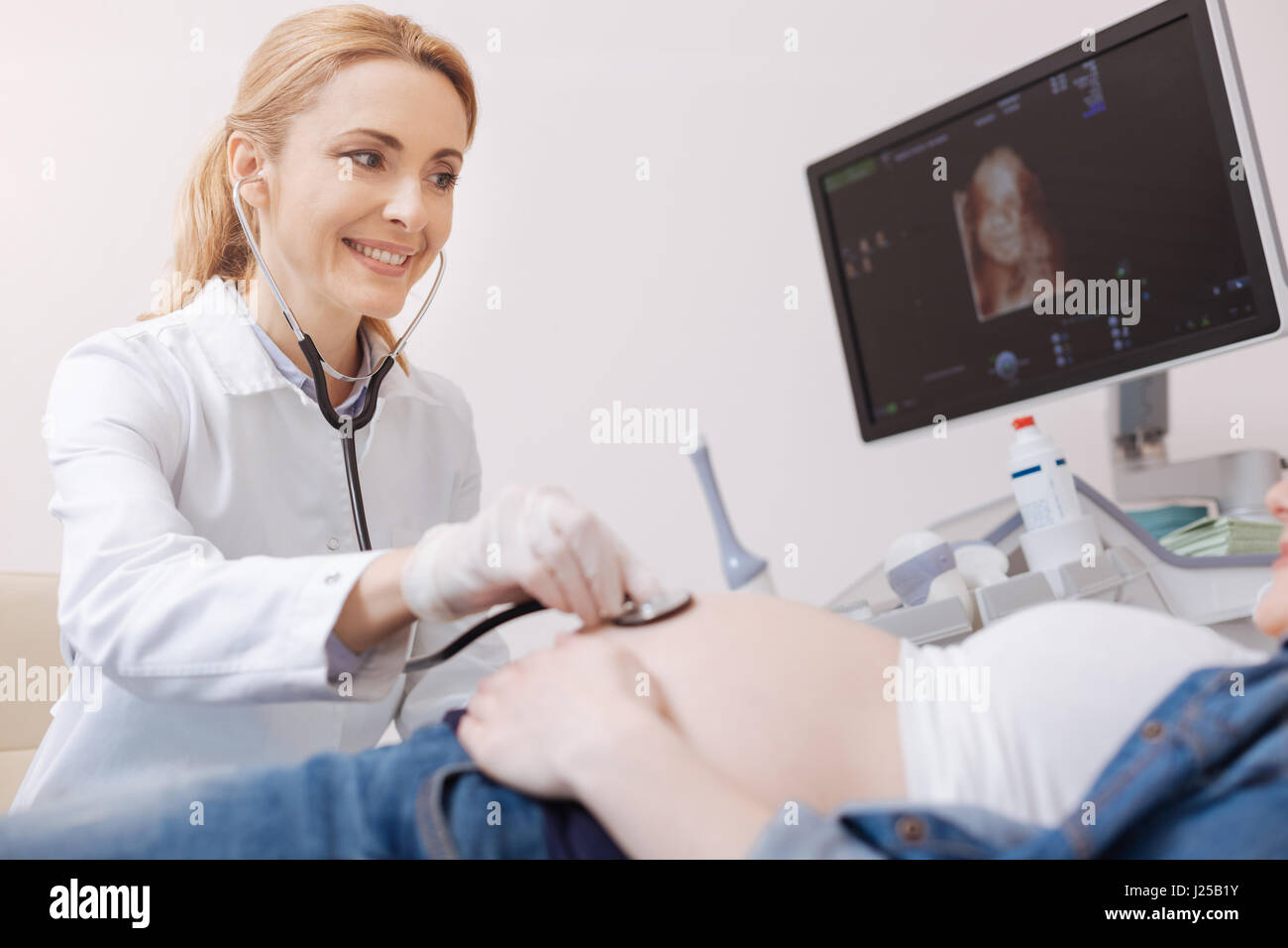 Felice ginecologo esame feto battito cardiaco in ospedale Foto Stock