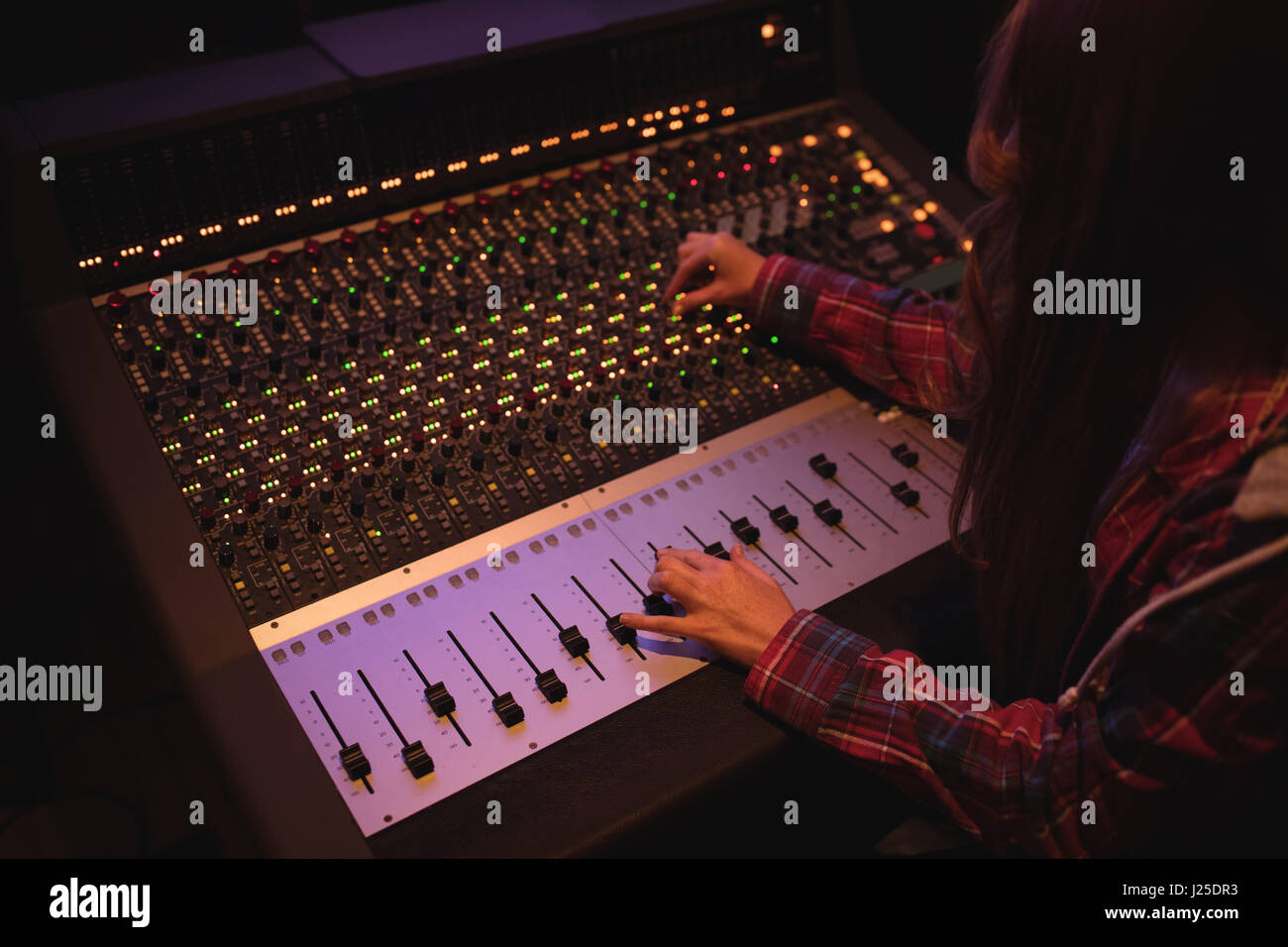 Femmina ingegnere audio con mixer audio in studio di registrazione Foto Stock