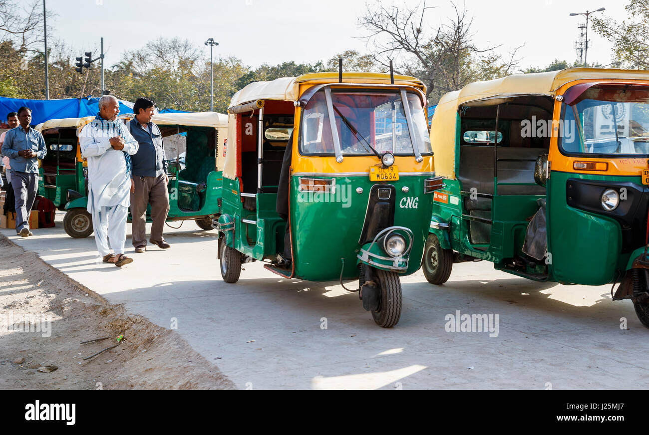 Tipico verde e giallo di tuk-tuk taxi (tre wheeler risciò motorizzati) parcheggiata in attesa sul ciglio della strada al di fuori della stazione di Delhi, Delhi, Punjab, India Foto Stock