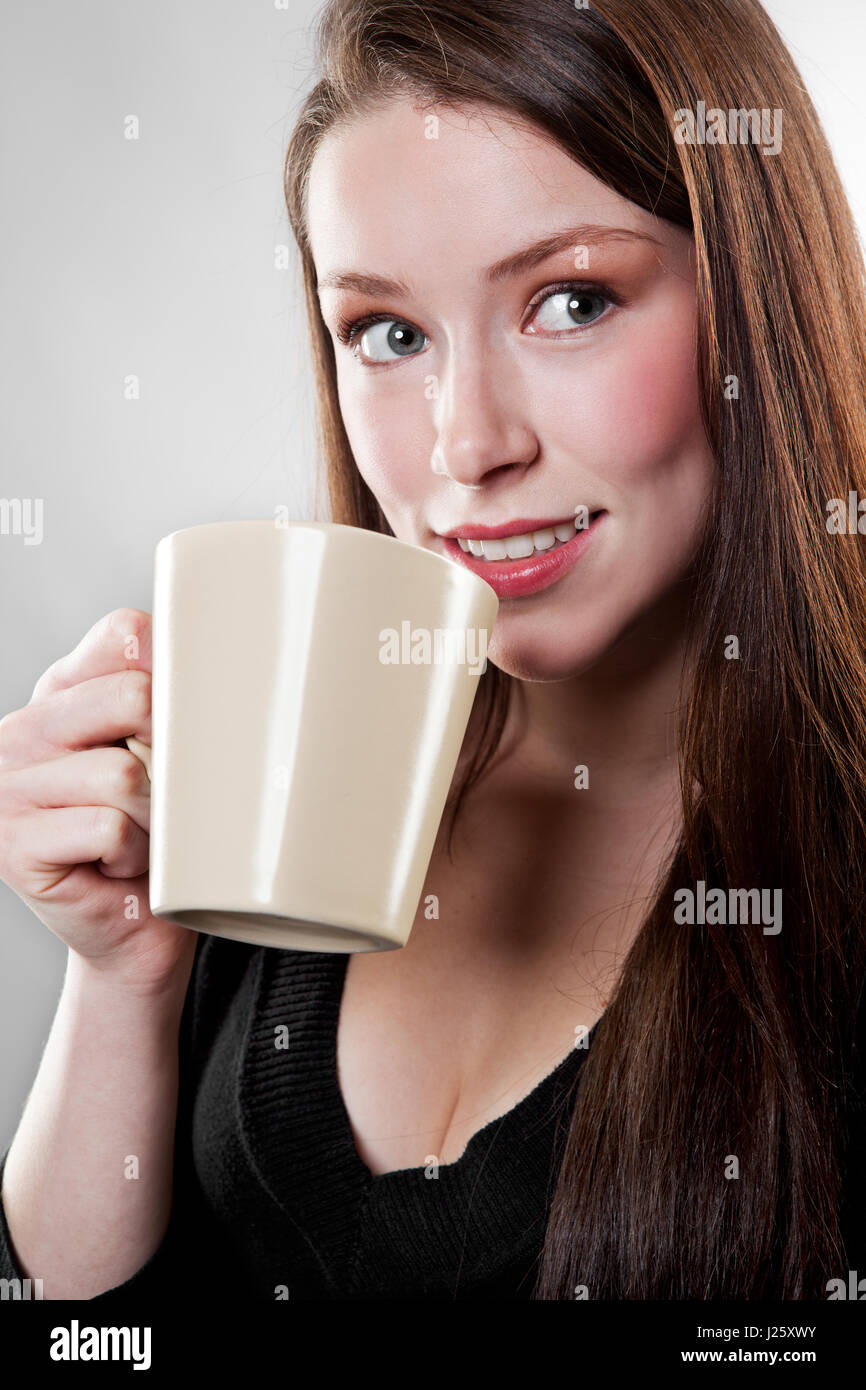 Un colpo di un bel caucasian imprenditrice di bere il caffè Foto Stock