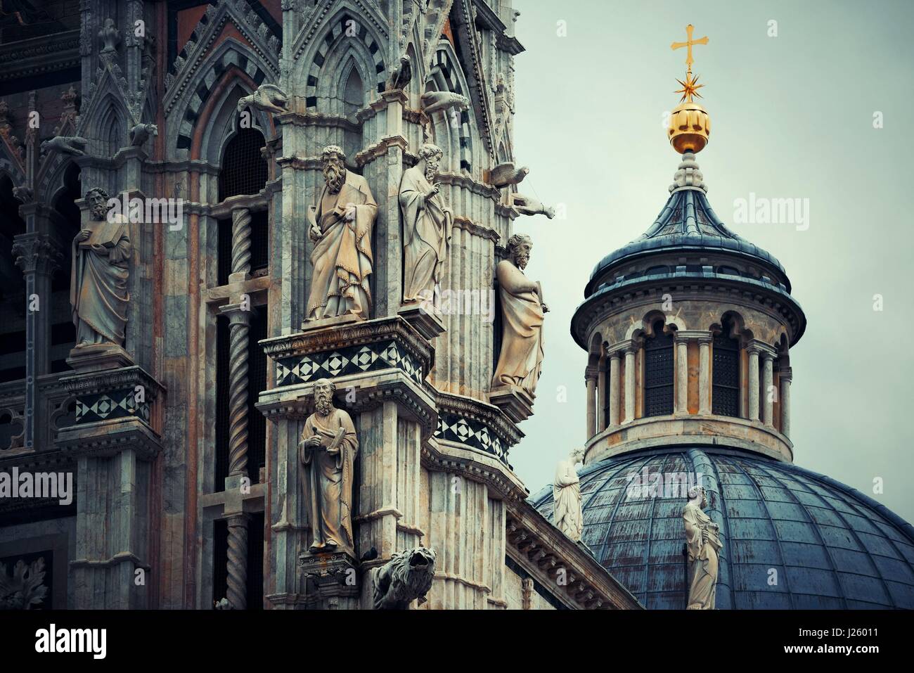 Cattedrale di Siena closeup con la cupola e la statua del famoso punto di riferimento nella città medievale in Italia. Foto Stock