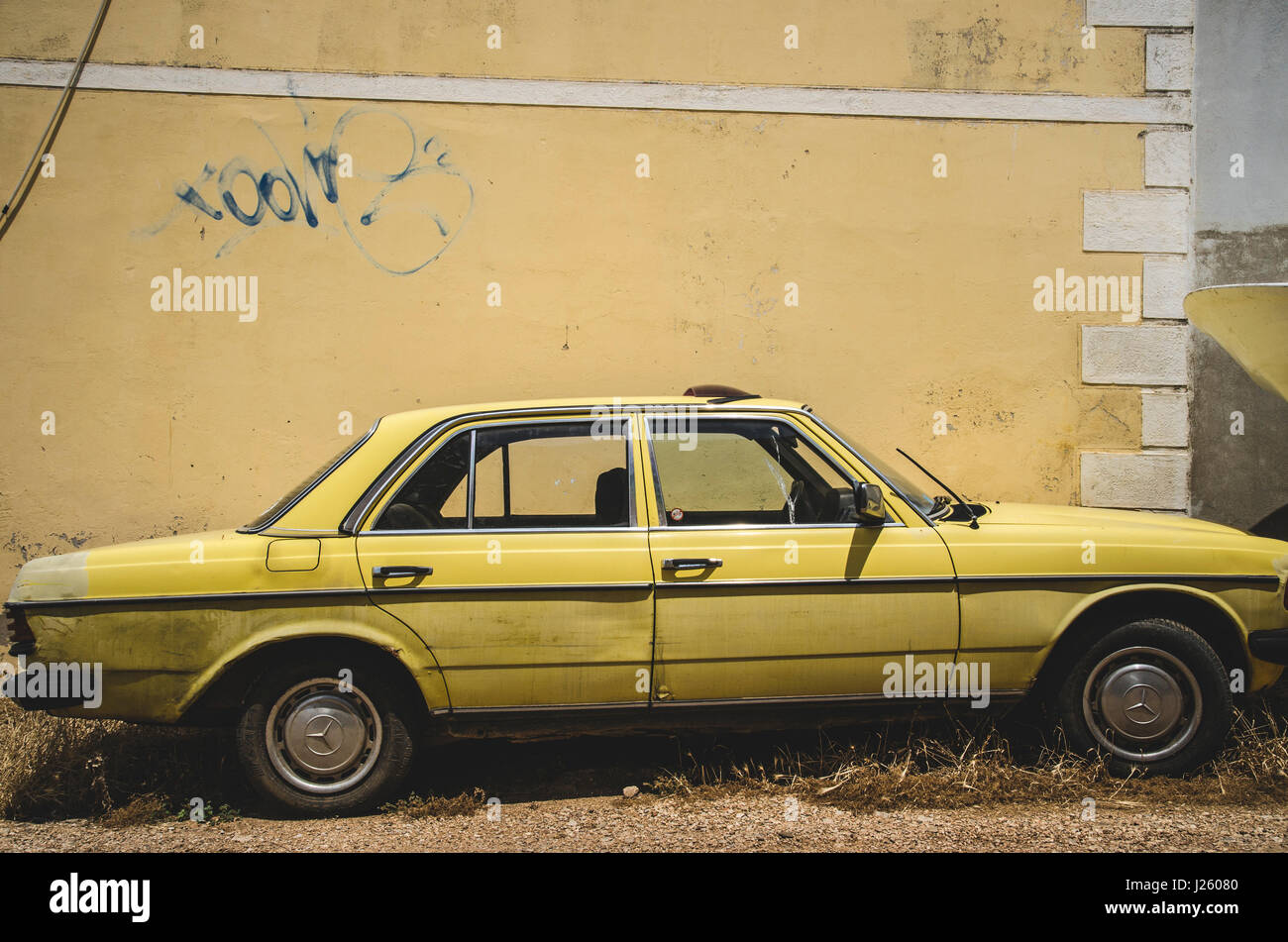 Vecchio giallo auto contro la parete gialla, Vis, Croazia Foto Stock