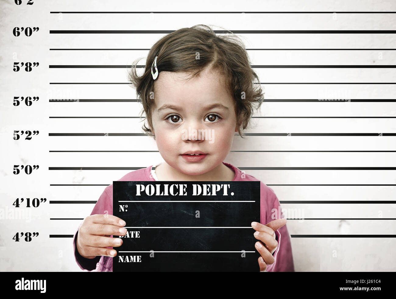 Bambina in posa con una scheda di prigione Foto Stock