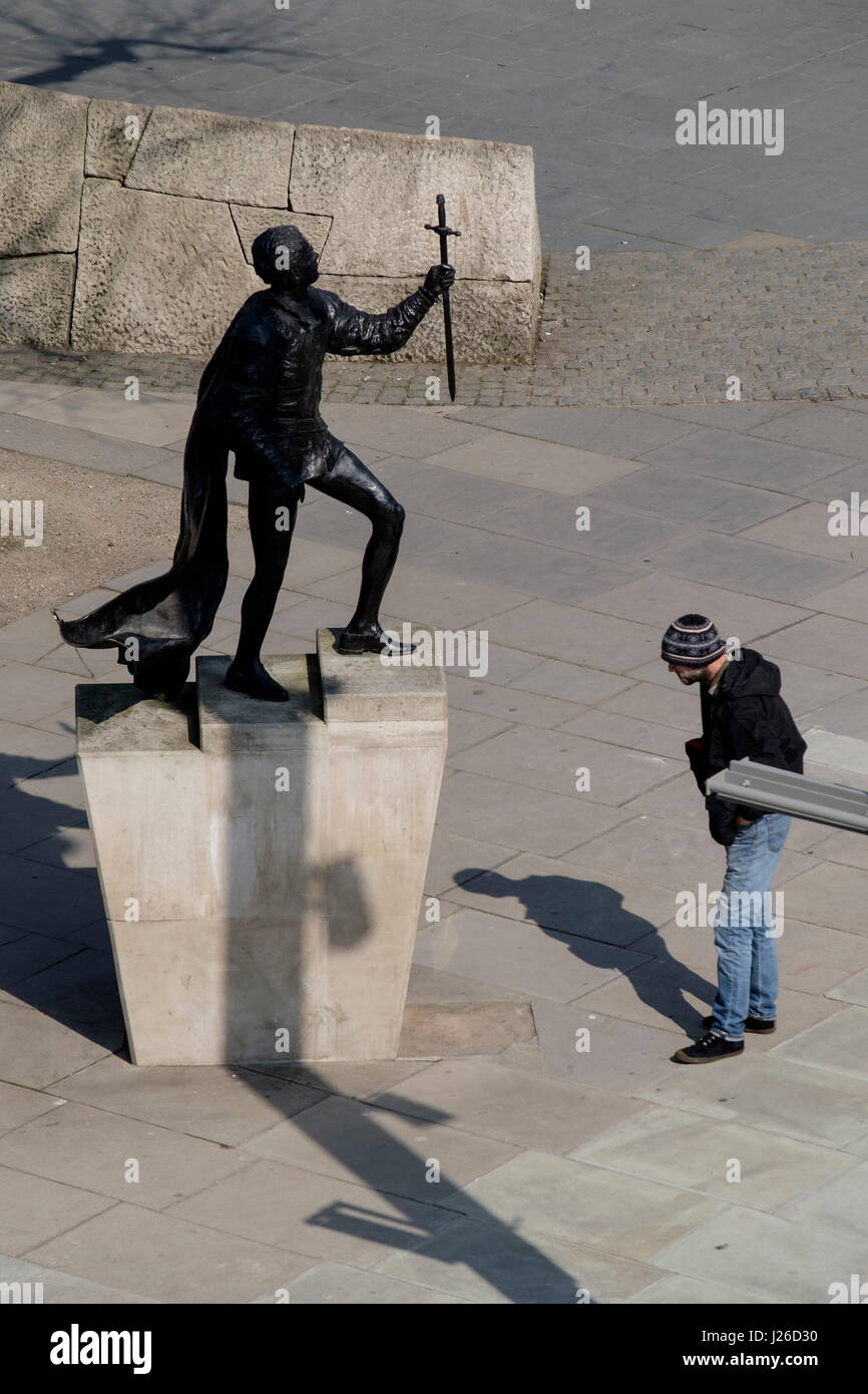 Uomo che guarda una statua di bronzo di Sir Lawrence Olivier al di fuori del Teatro Nazionale di Londra, Inghilterra, Regno Unito, Europa Foto Stock