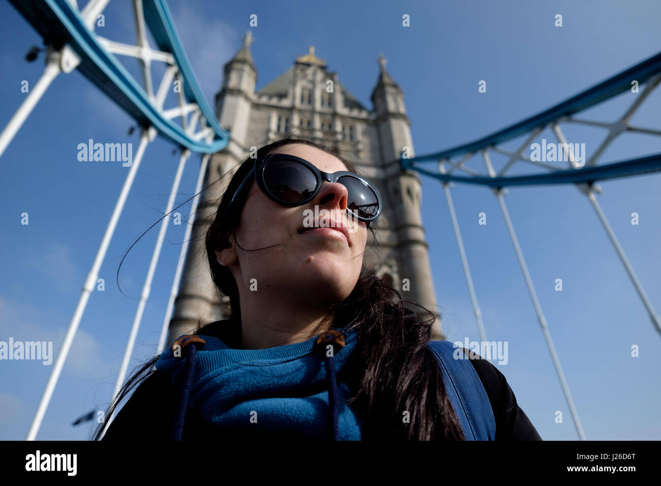 Ritratto di un bel giovane donna che indossa gli occhiali da sole in una giornata di sole, Tower Bridge, London, England, Regno Unito, Europa Foto Stock