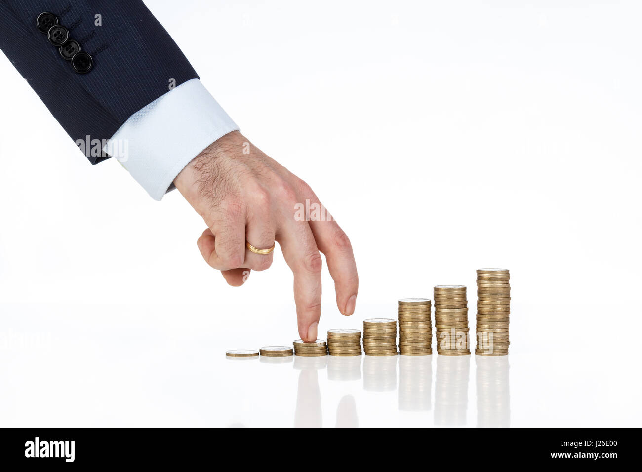Dita della mano imprenditore stack di arrampicata di monete in backgroud bianco. Il concetto di business. Foto Stock