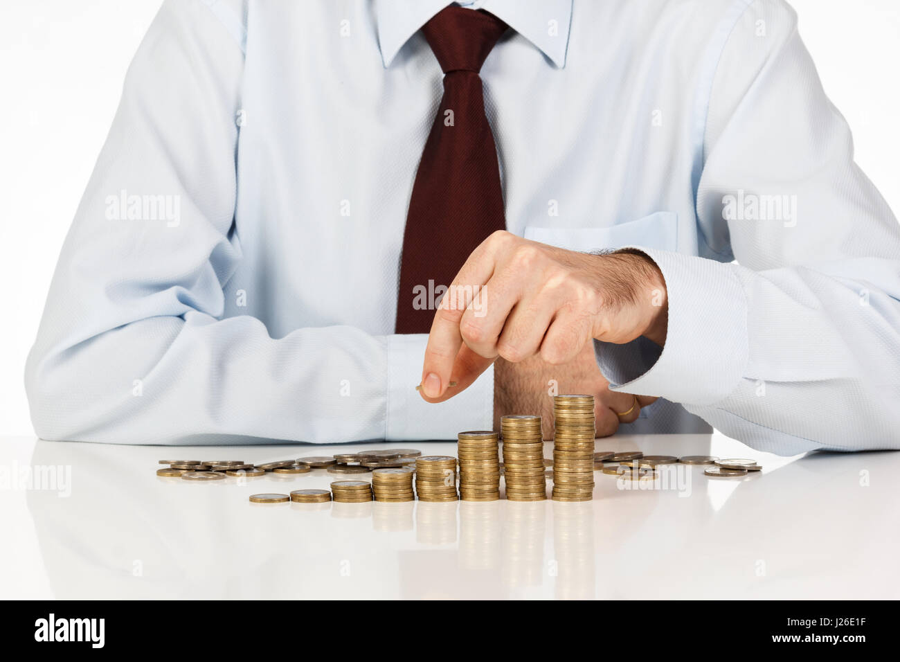 Imprenditore uno di impilamento delle monete in euro in aumento le colonne su sfondo bianco Foto Stock