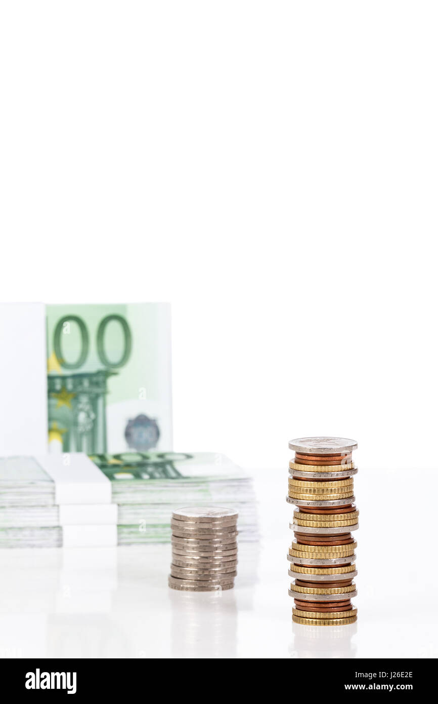 Monete metalliche in euro impilati e le banconote in euro su uno sfondo bianco. Piano finanziario. Foto Stock