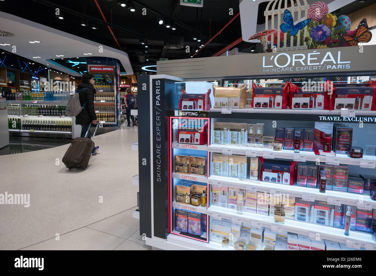 Passeggeri con valigia camminare da un L'Oréal stand al duty free store, dall'aeroporto di Portela di Lisbona, Portogallo, Europa Foto Stock