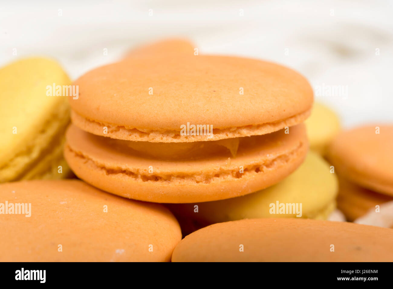 Pila di arancione e giallo amaretto biscotti isolato su bianco. Foto Stock