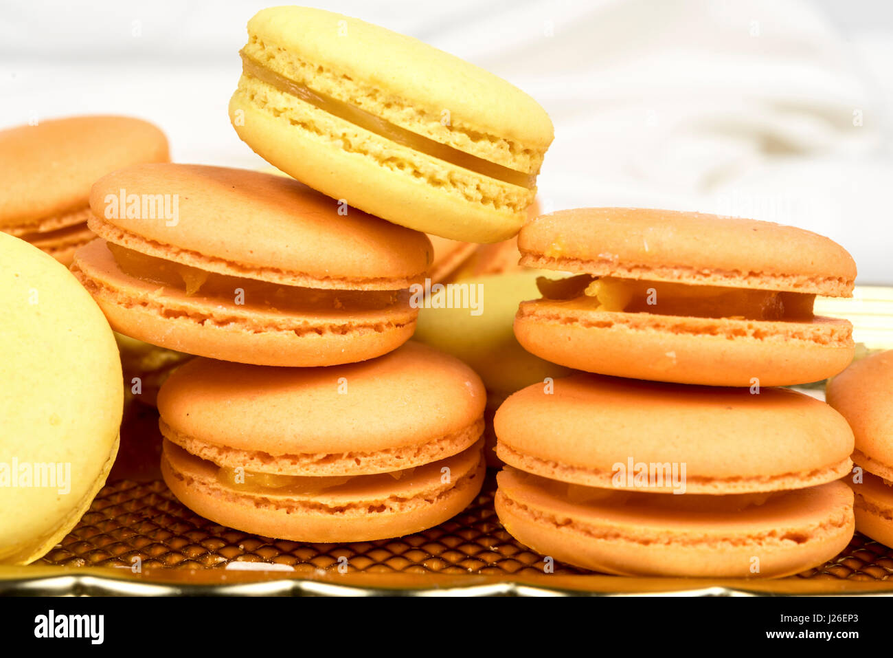 Pila di arancione e giallo amaretto biscotti isolato su bianco. Foto Stock