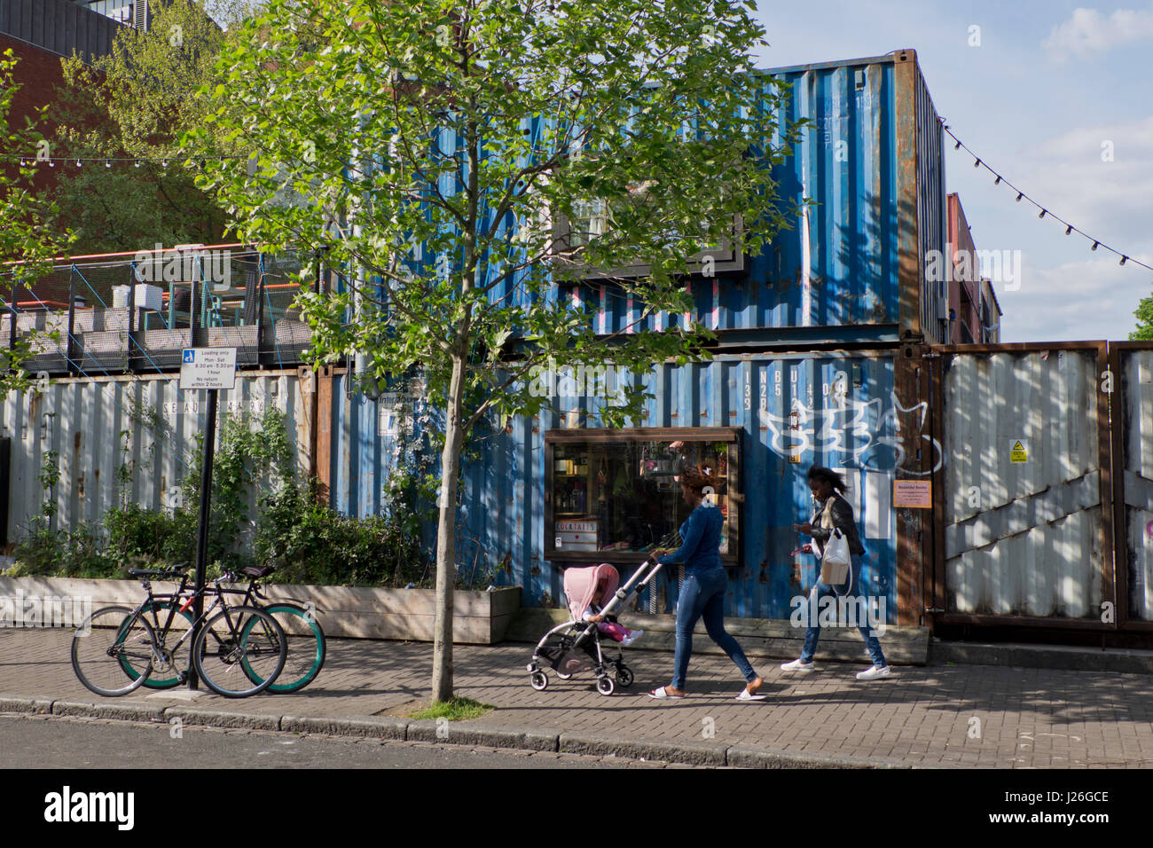 La popolazione locale a piedi dal Pop Brixton cibo e arte enclave, fatta di contenitori.Brixton,Londra,UK Foto Stock