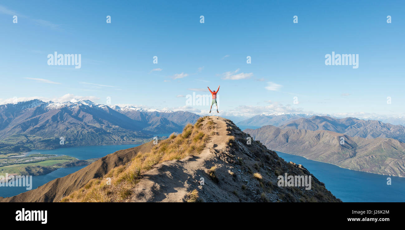 Escursionista il taglio di un cappero, vista sulle montagne e sul lago, Roys picco, il lago Wanaka, Alpi del Sud, regione di Otago e Southland, Nuova Zelanda Foto Stock