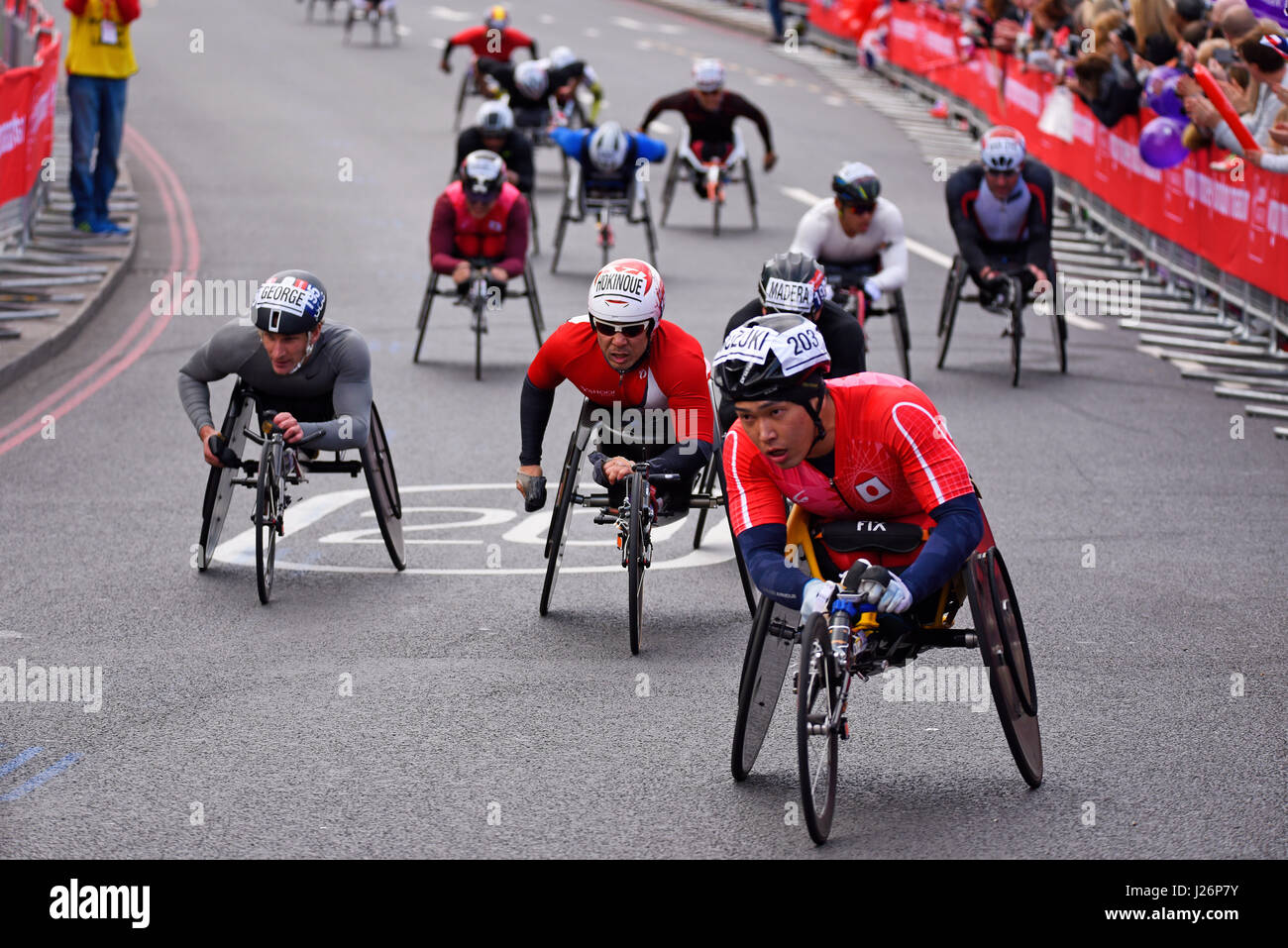 Tomoki Suzuki guida un gruppo nella Virgin London Marathon del 2017 dopo aver attraversato il Tower Bridge e accanto alla Tower of London, Regno Unito Foto Stock