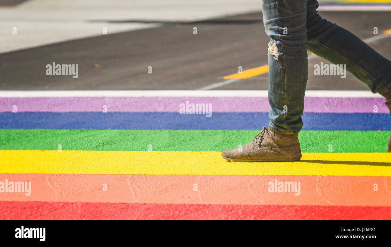 Sezione bassa della persona che cammina su orgoglio LGBT colorato in ambiente urbano Foto Stock